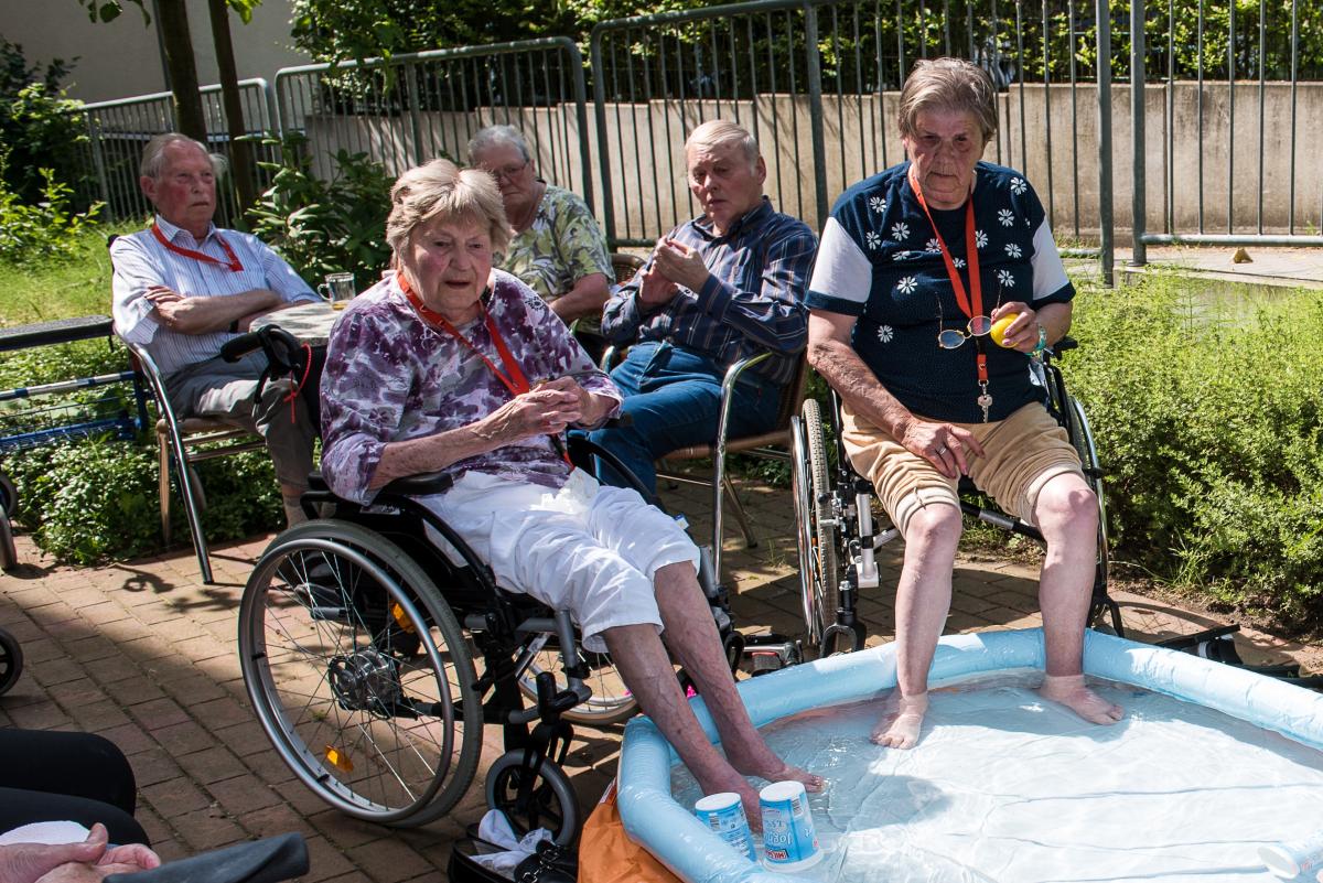 Bewohnerinnen des AWO Seniorenzentrums sitzen mit den Füßen im Minipool